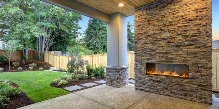 outdoor patio with a fireplace and sealed natural stone