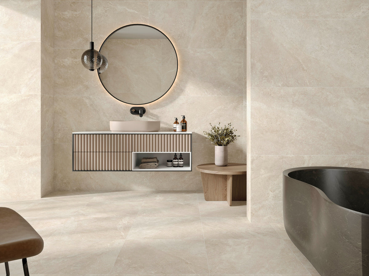 Modern bathroom with a vanity, round mirror, and freestanding bathtub on matte porcelain tile floor.