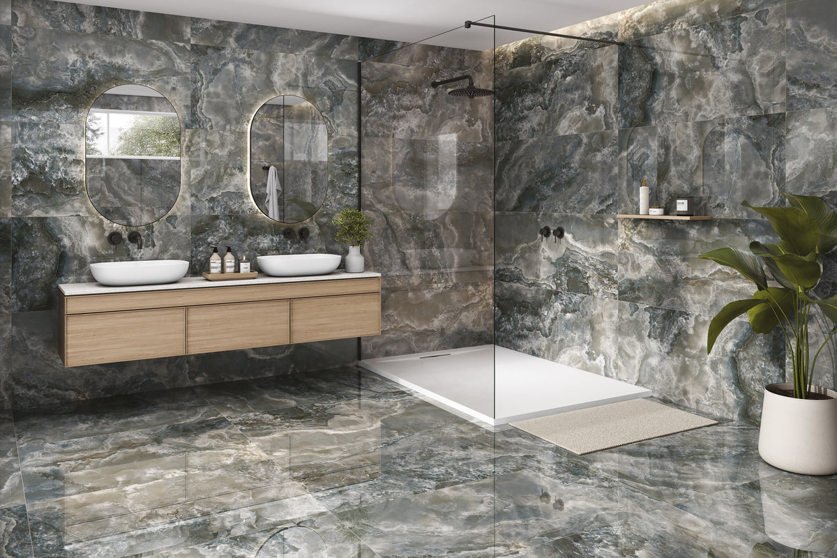 A modern bathroom interior with large black marbled stone look porcelain tiles, a double-sink vanity with light wood cabinets