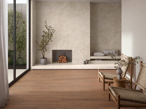 A modern interior room with warm medium-brown wood plank flooring, textured beige walls, a built-in fireplace with stacked lo